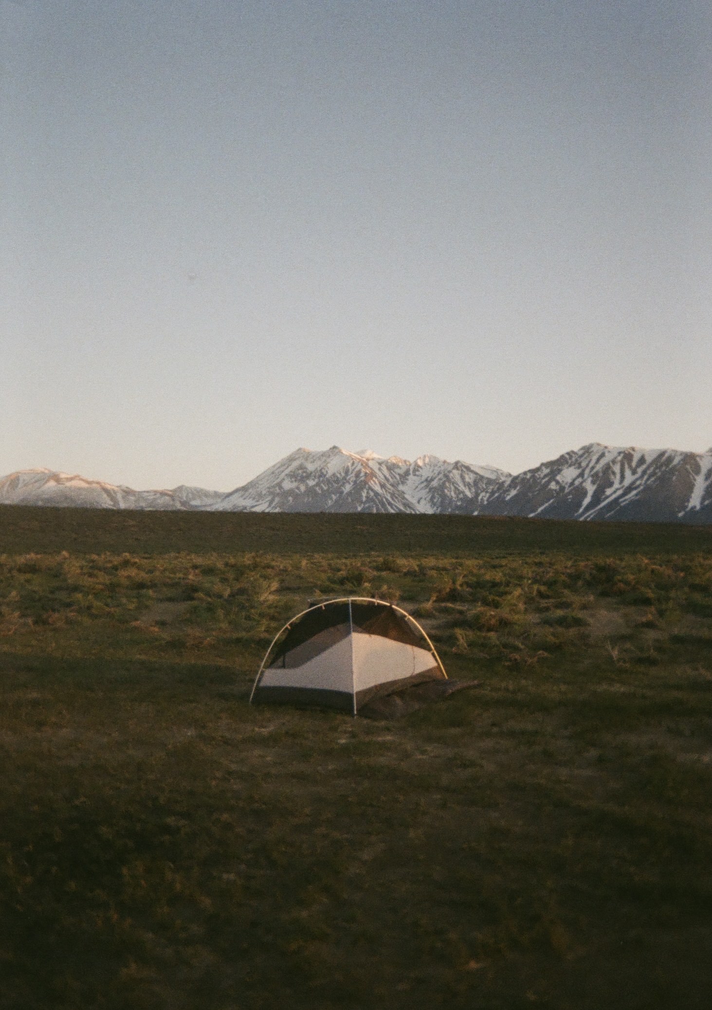 a tent in front of snowy mountains