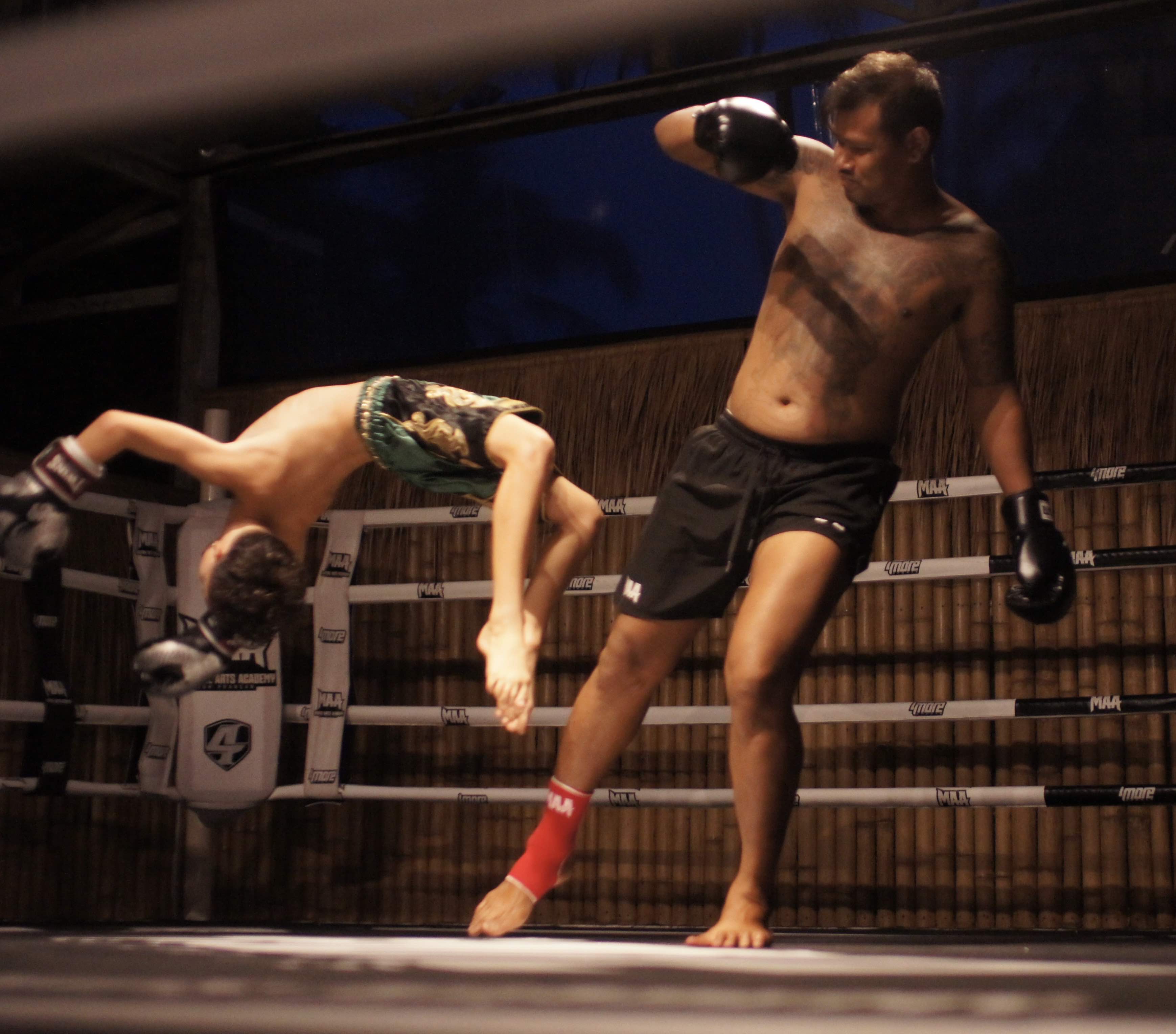 young muay thai fighter handsprings away from a kick