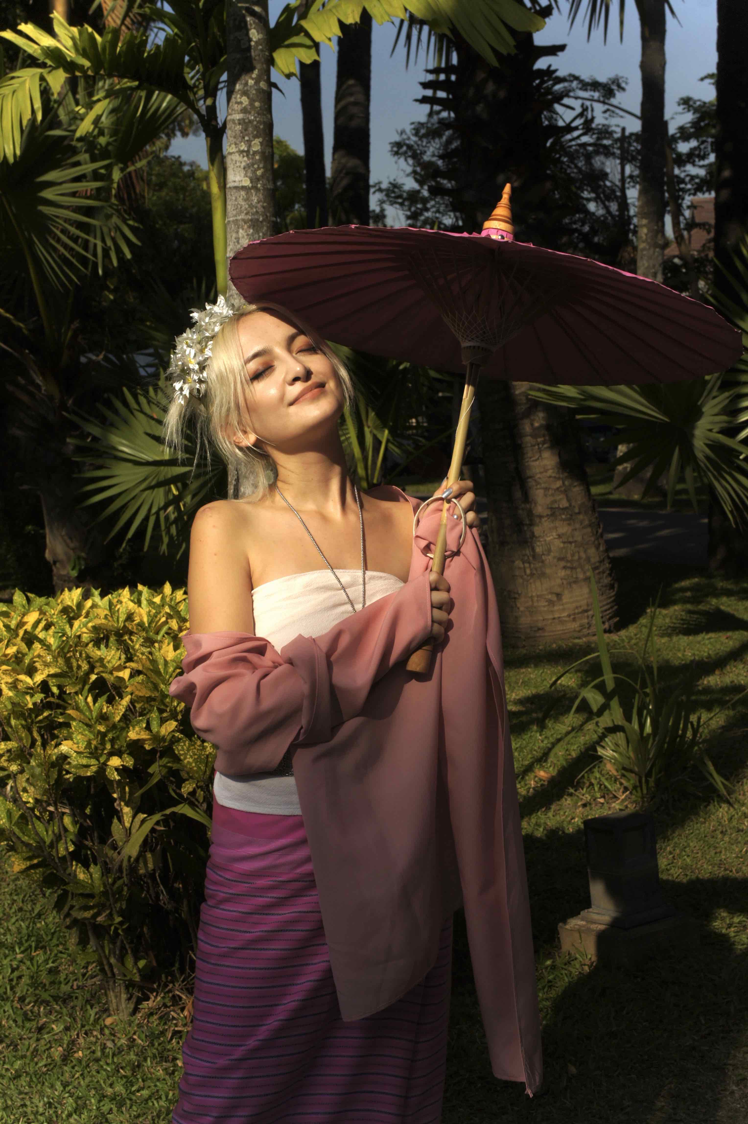 woman with a parasol smiles into sunshine