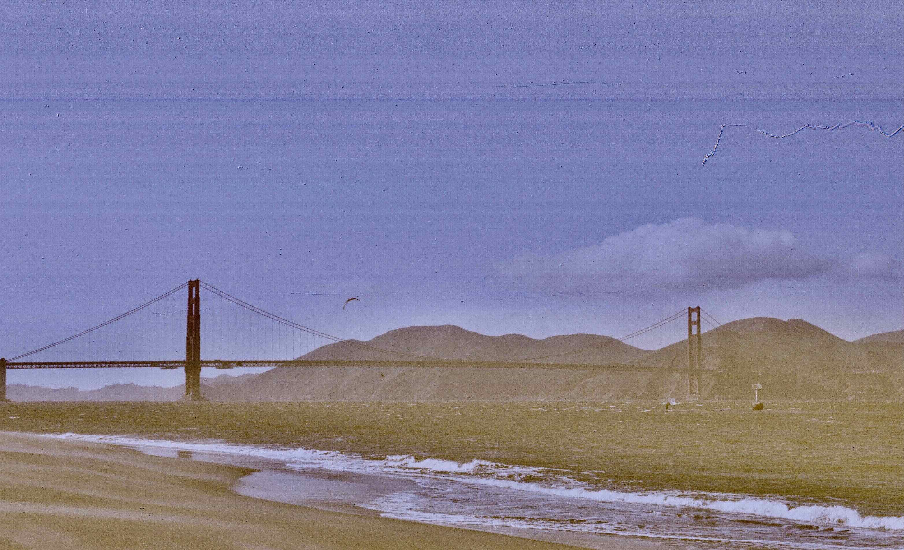 a windsurfer flies in front of the golden gate bridge