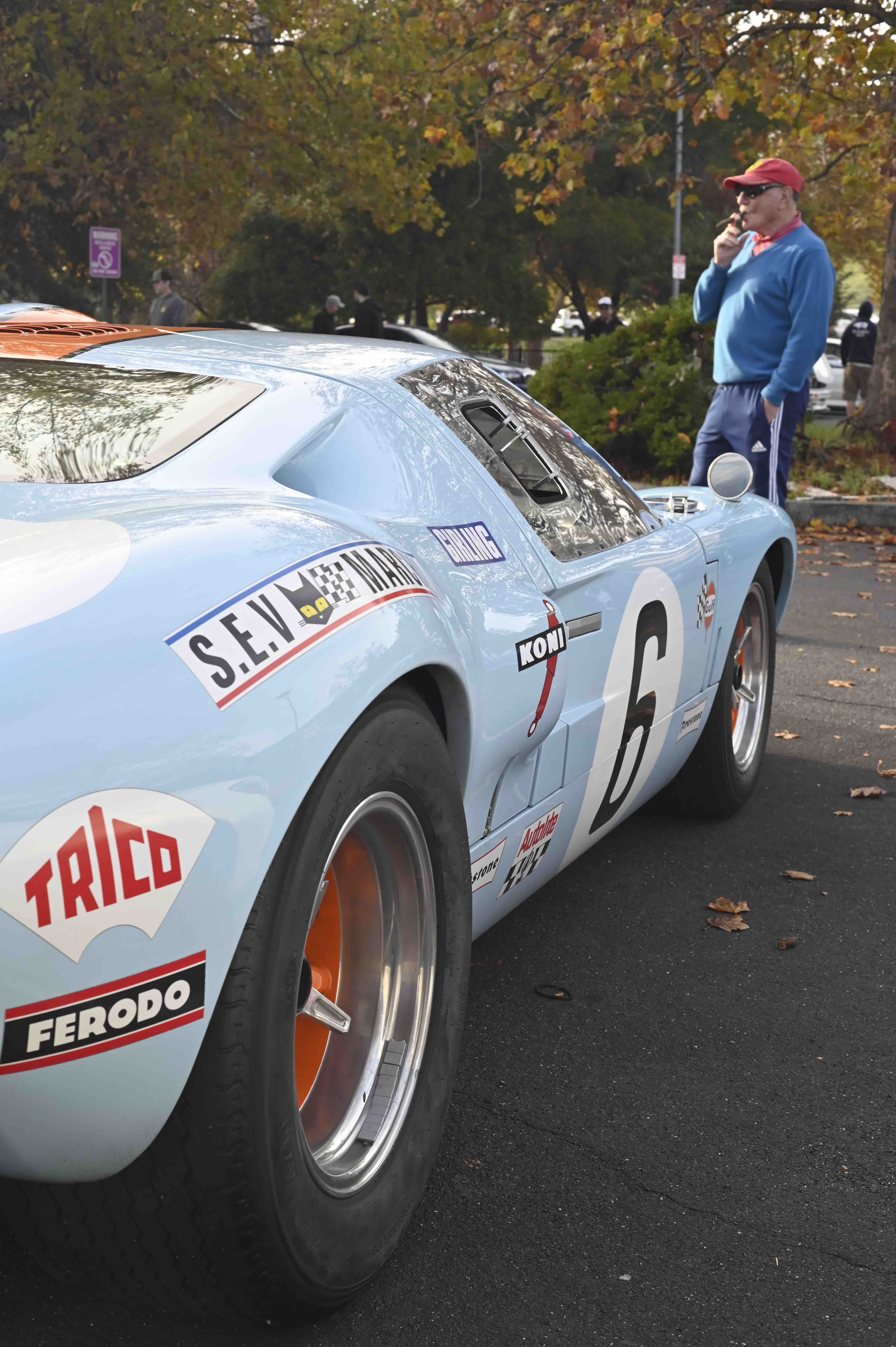 man smokes a stogie in front of a GT40